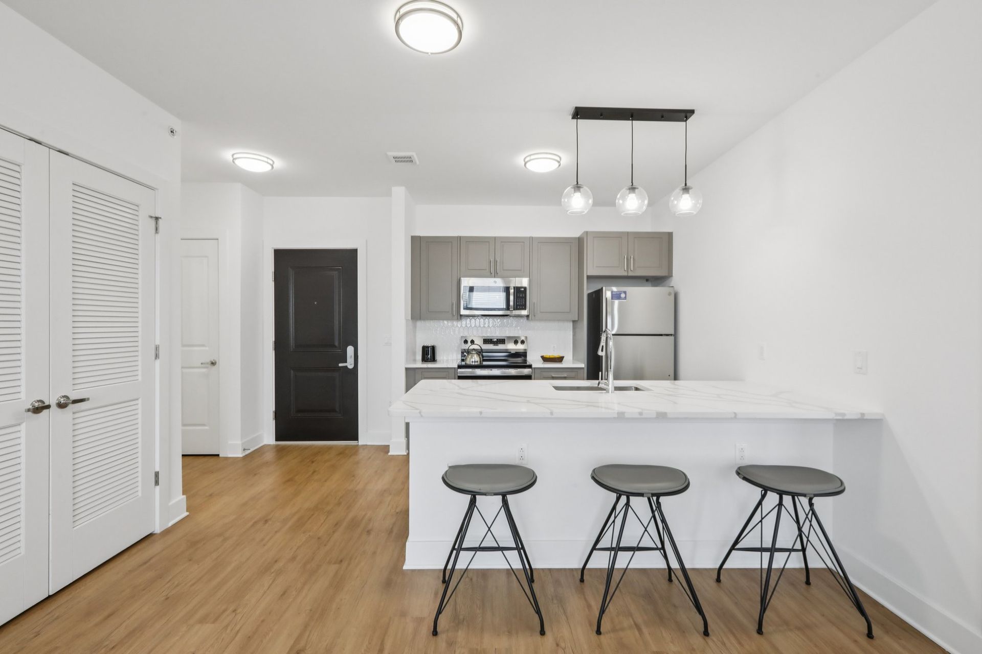Kitchen with stainless appliances and bar seating at Meridia Little Ferry apartments NJ