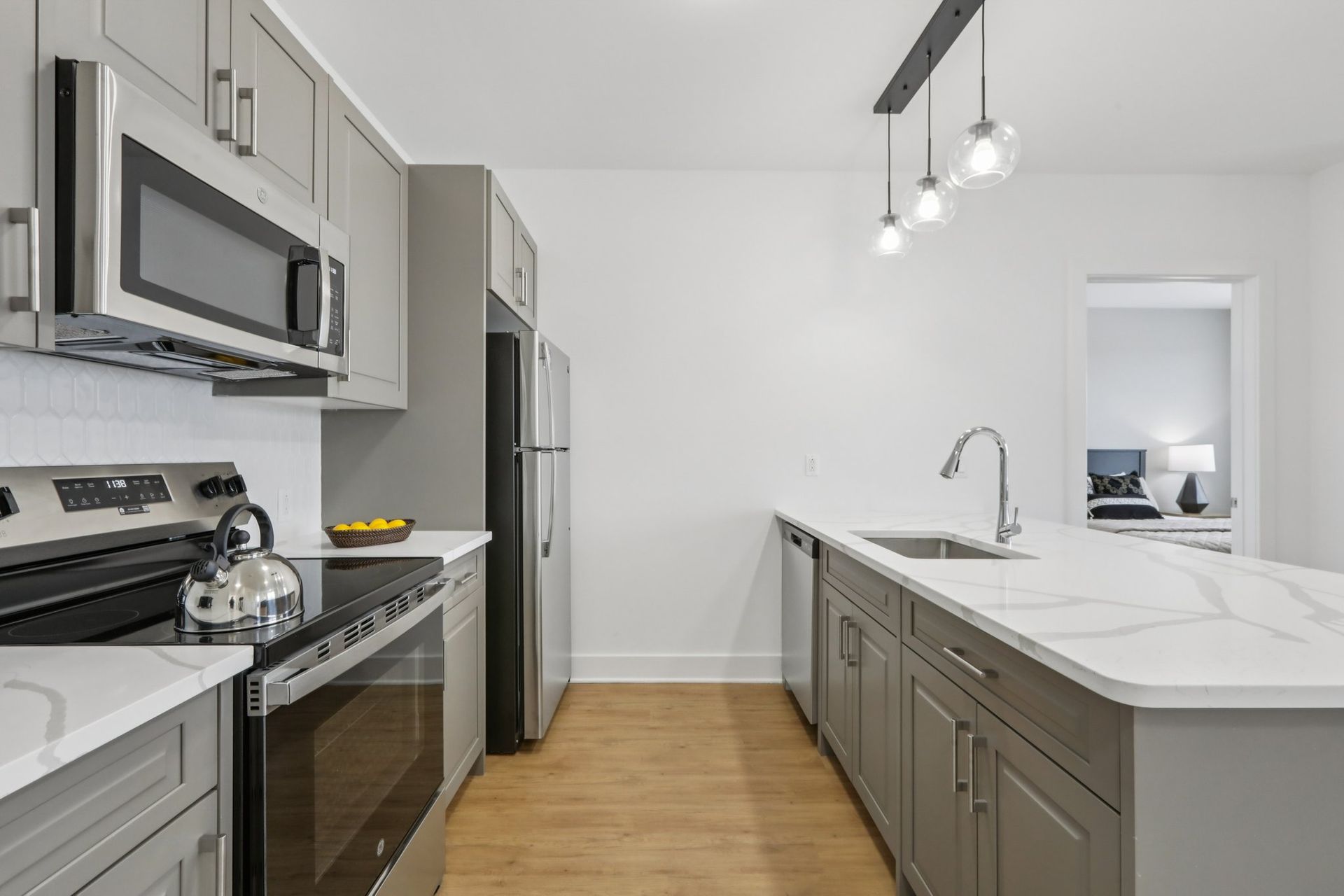 Open kitchen with bar seating and stainless steel appliances at Meridia Little Ferry apartments, Little Ferry NJ