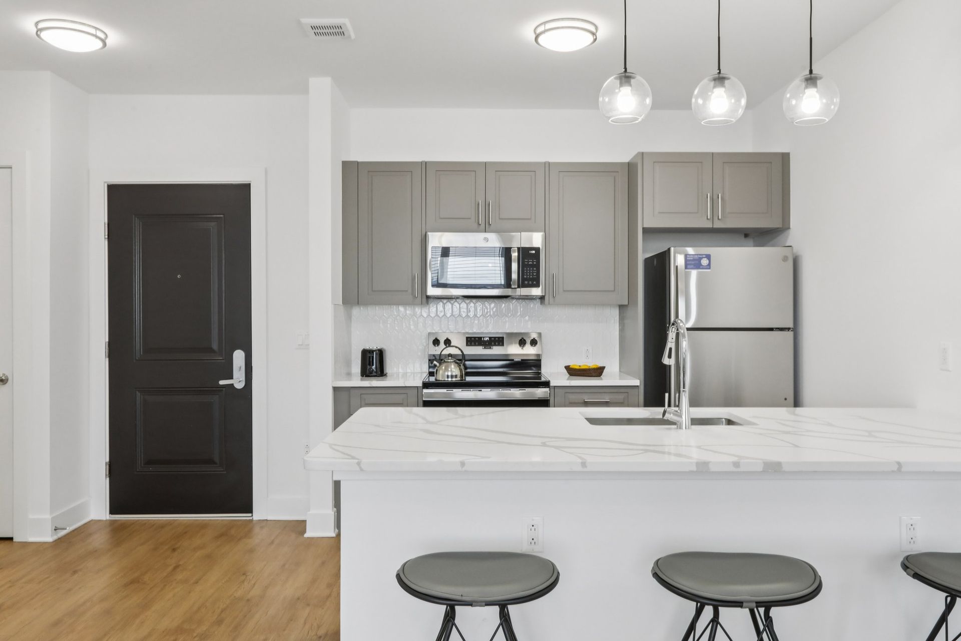 Modern kitchen with dark door entry and stainless appliances at Meridia Little Ferry NJ
