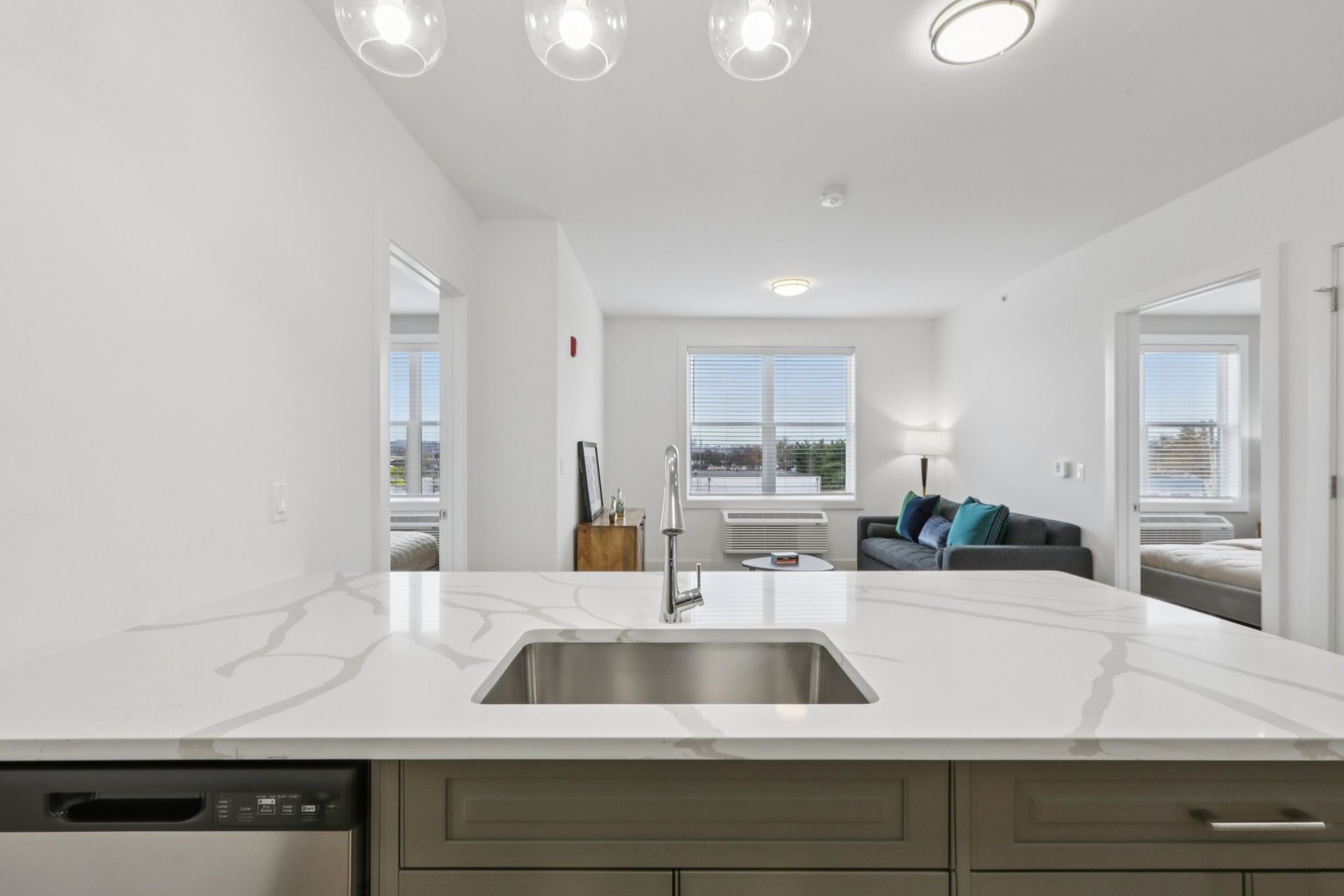 Kitchen island with marble countertop and living room view at Meridia Little Ferry NJ