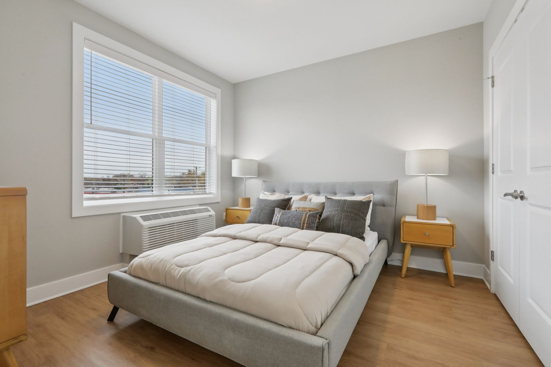 Bright bedroom with large window and wood floors at Meridia Little Ferry apartments NJ