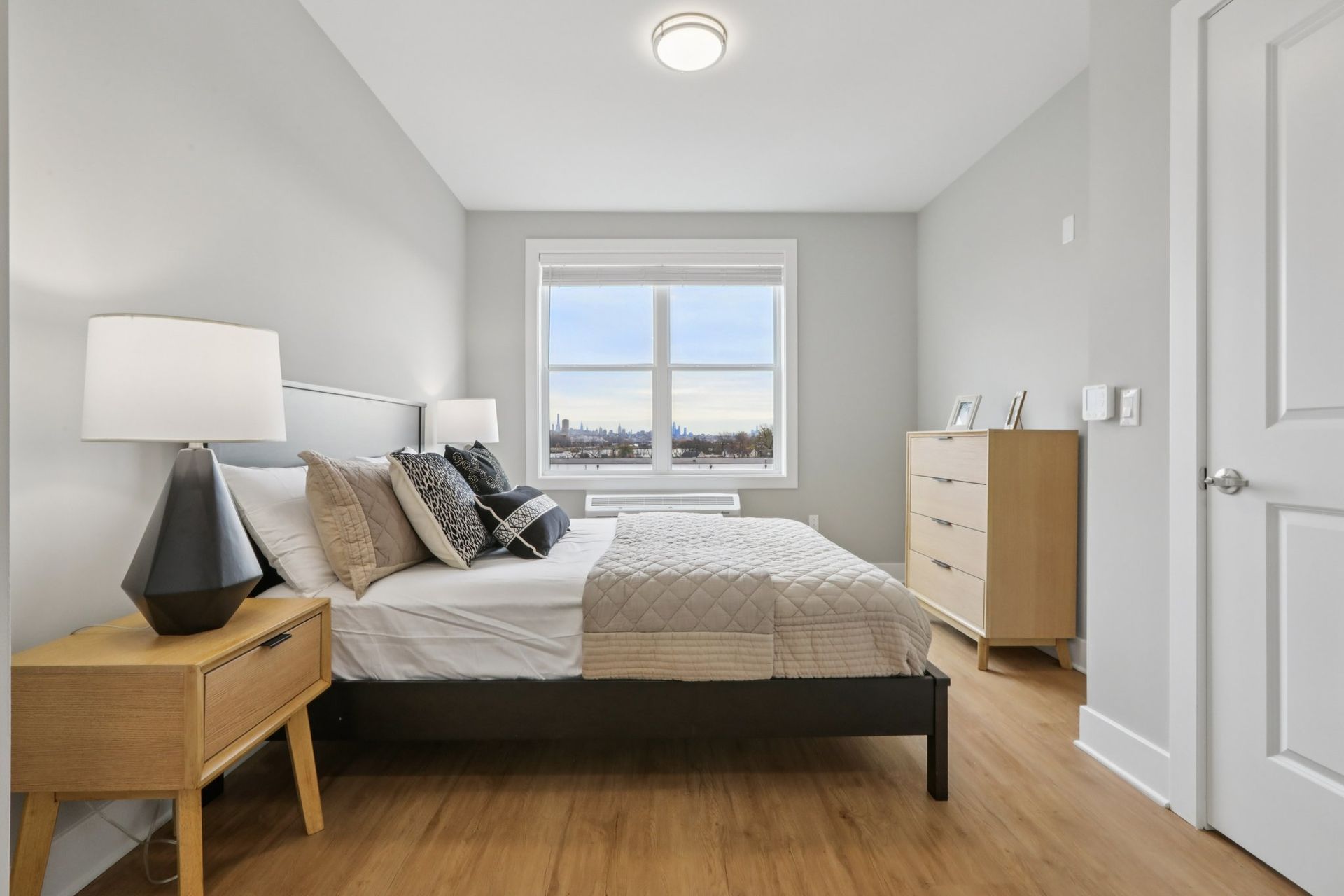 Cozy bedroom with large window and natural light at Meridia Little Ferry apartments NJ