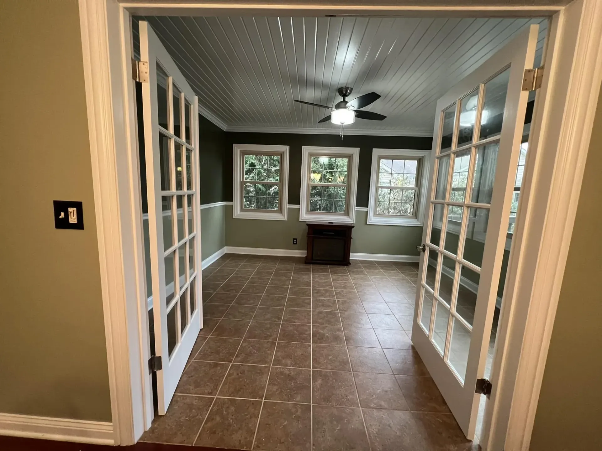 Interior painting project with green walls, white trim, French doors, tile floor, and painted beadboard ceiling near Brodhead WI