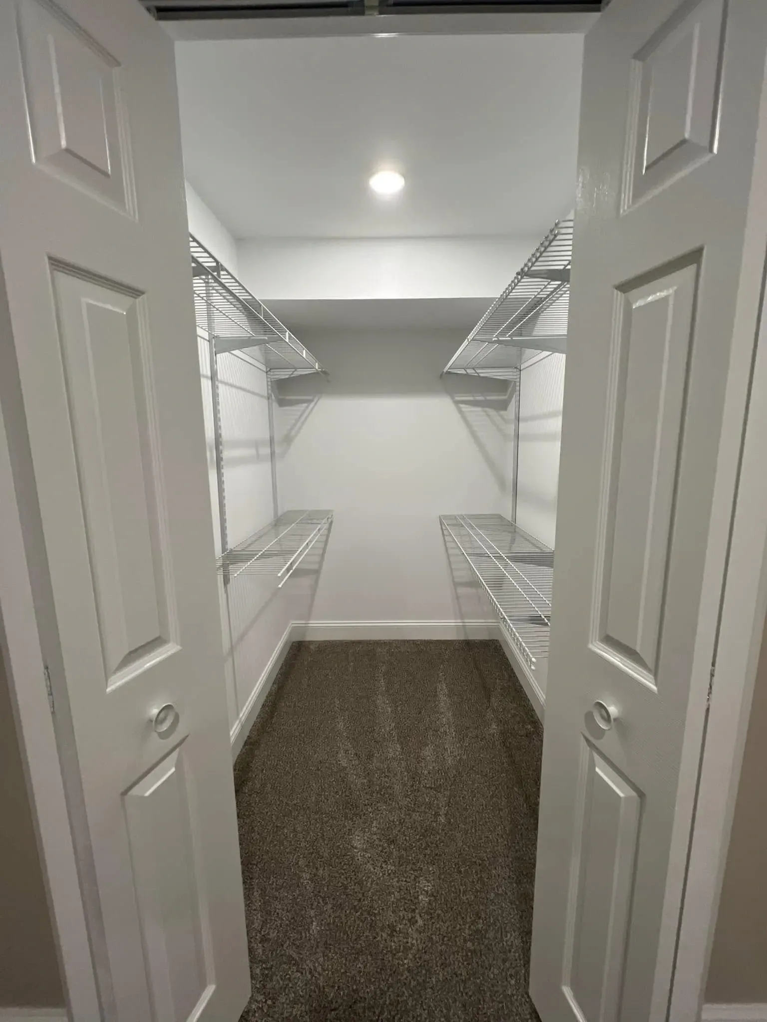 Freshly painted walk-in closet with white walls, white trim, wire shelving, and clean interior finish near Brodhead WI