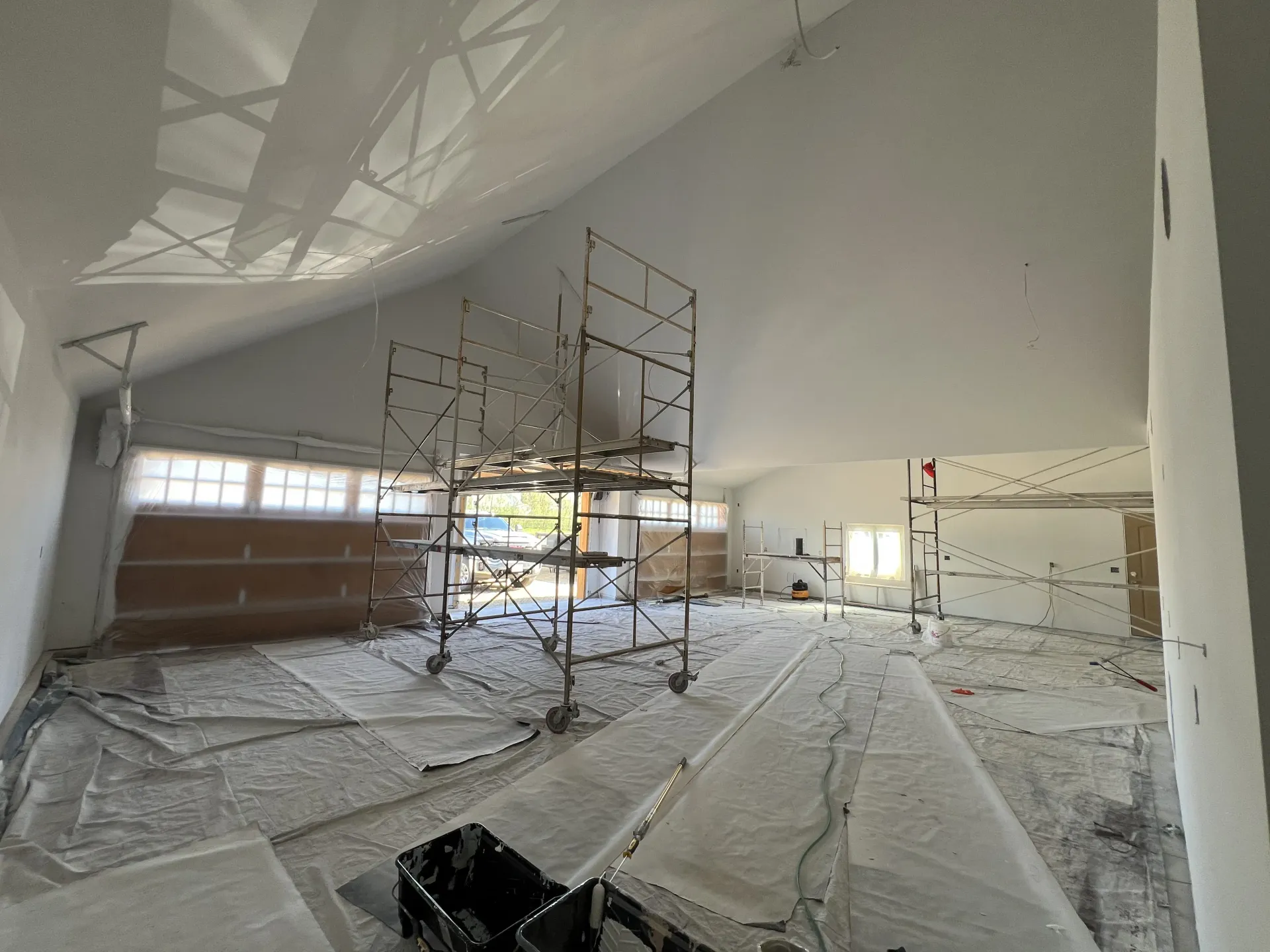 Interior painting project in Rockford IL with vaulted ceilings, white walls, and protected work area
