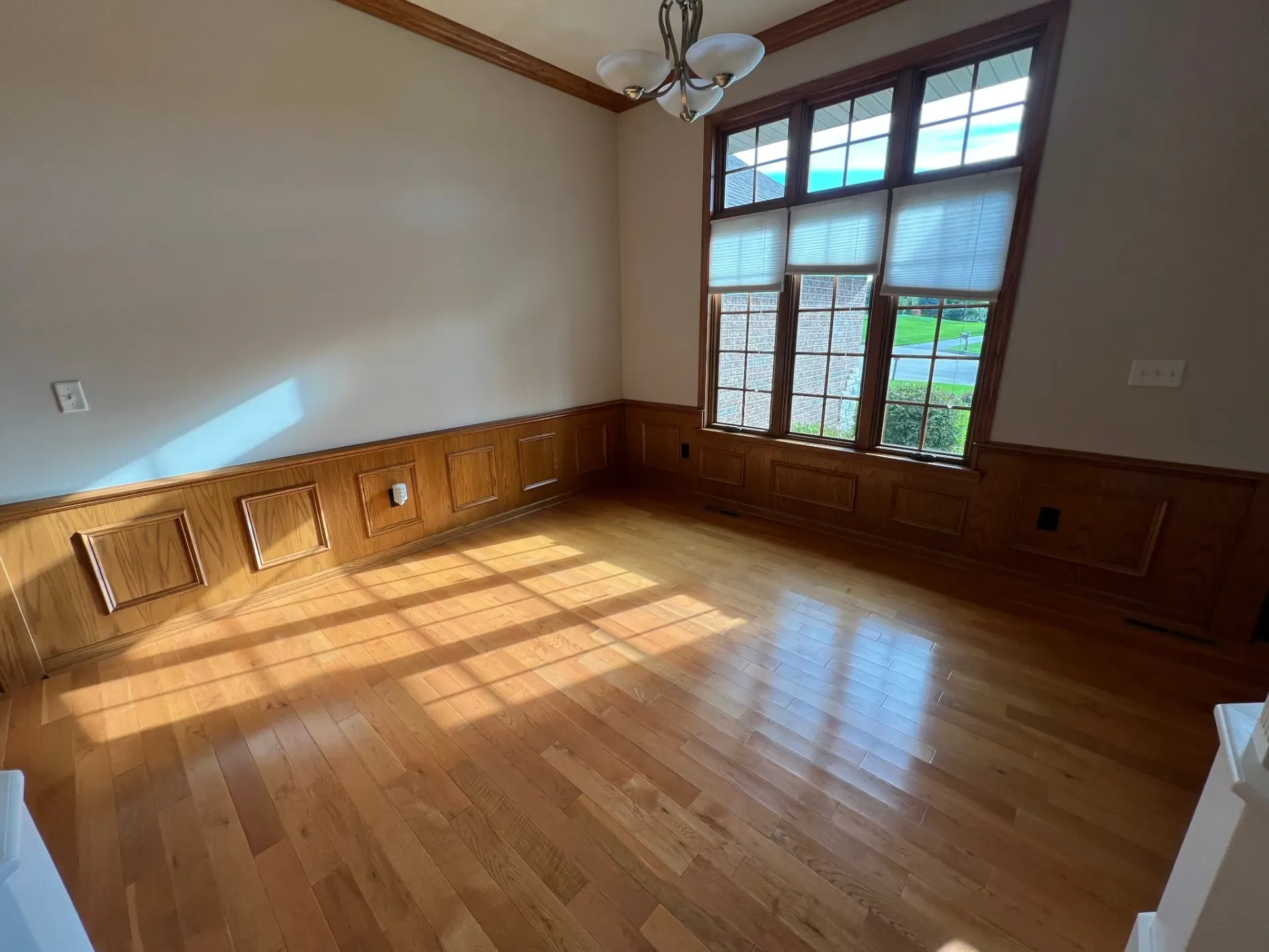 Interior painting project with neutral walls, wood wainscoting, hardwood floors, and large windows near Galena IL