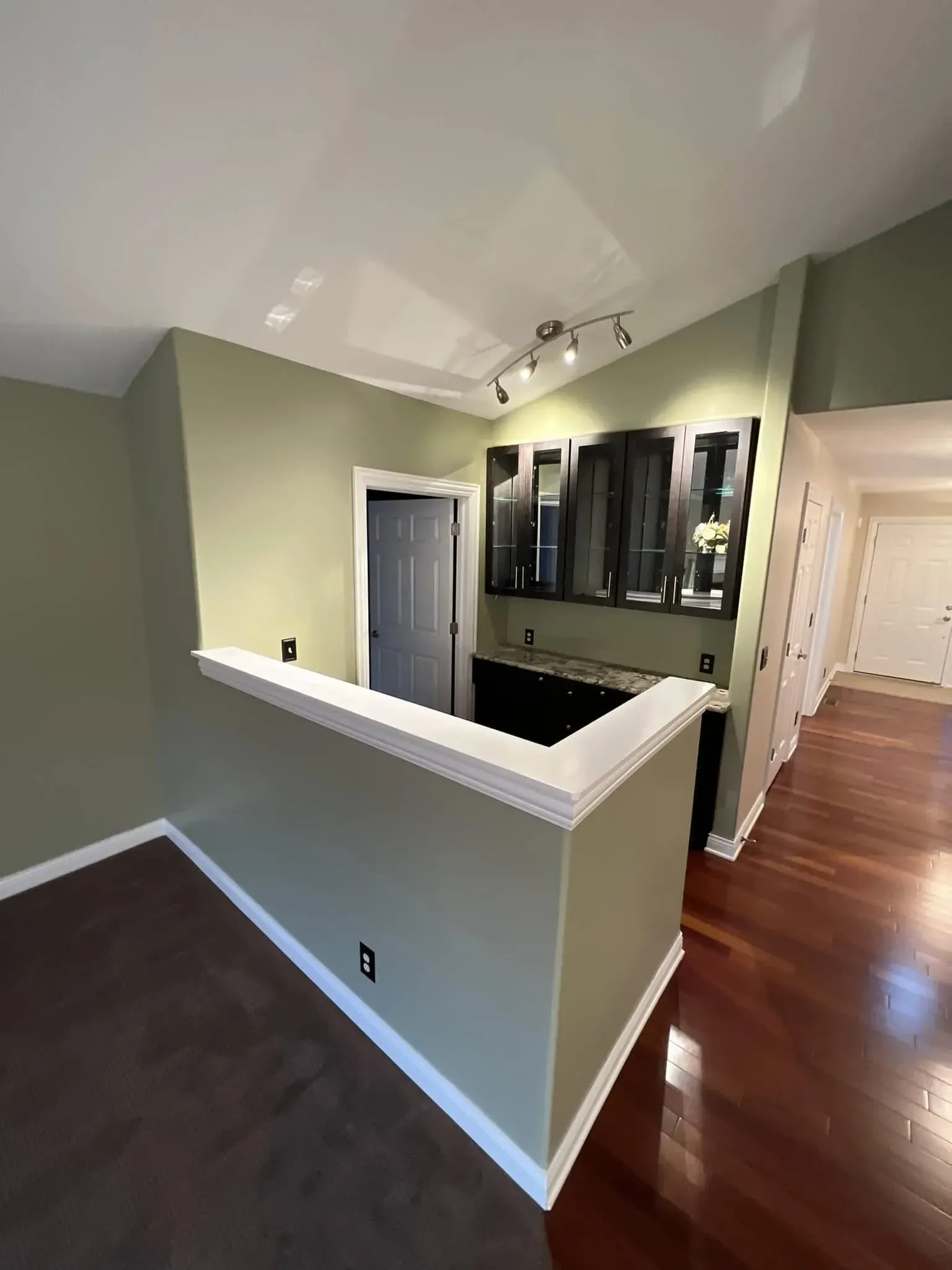 Residential interior painting project with green walls, white trim, and bar area in Northern Illinois