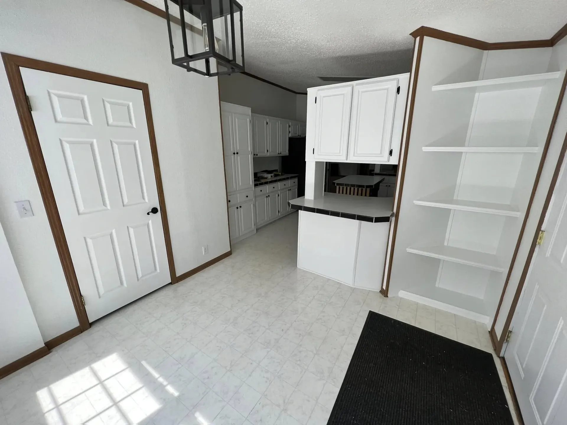Kitchen cabinet painting project with white cabinets, black hardware, light countertops, and updated interior trim near Galena IL