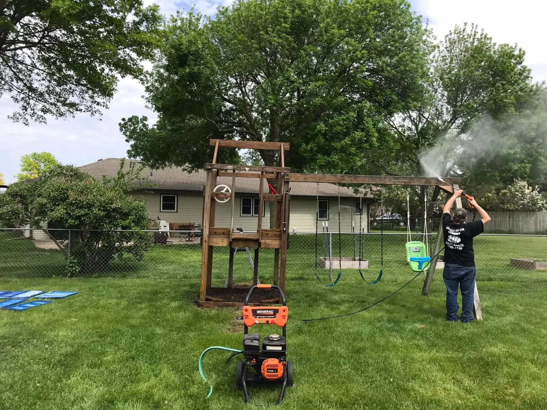 Residential pressure washing cleaning an outdoor wooden playset in the Rockford IL area