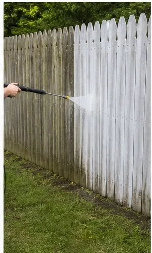 Residential pressure washing service cleaning a white fence near Rockford IL