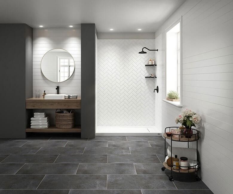 Modern bathroom with dark tile floor, round mirror vanity, shower nook, and window shelf with plants and baskets