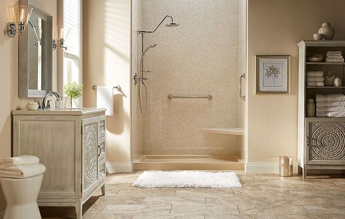 Bright beige bathroom with walk-in shower, vanity, toilet, and shelving in a clean, spa-like setting