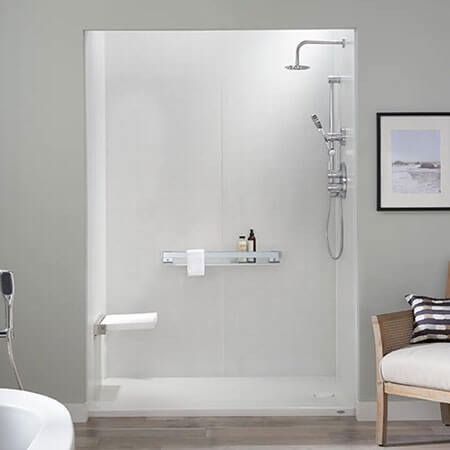 Accessible modern bathroom with walk-in shower, wall shelf, and chair by framed wall art
