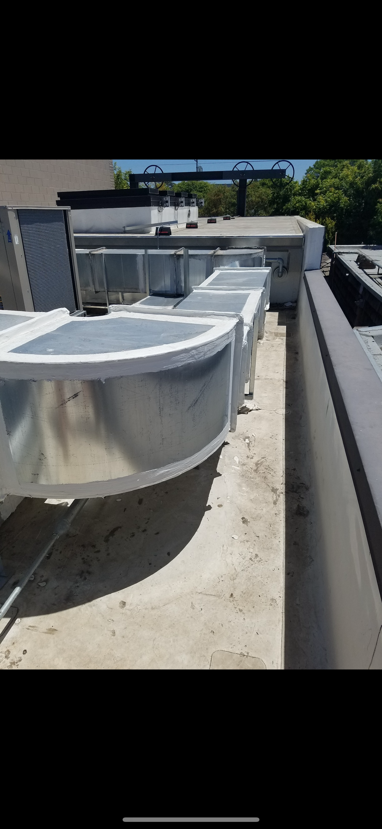 HVAC equipment on a flat roof, including ductwork and air conditioning units.