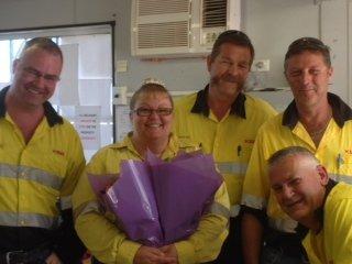 Five people in yellow work shirts