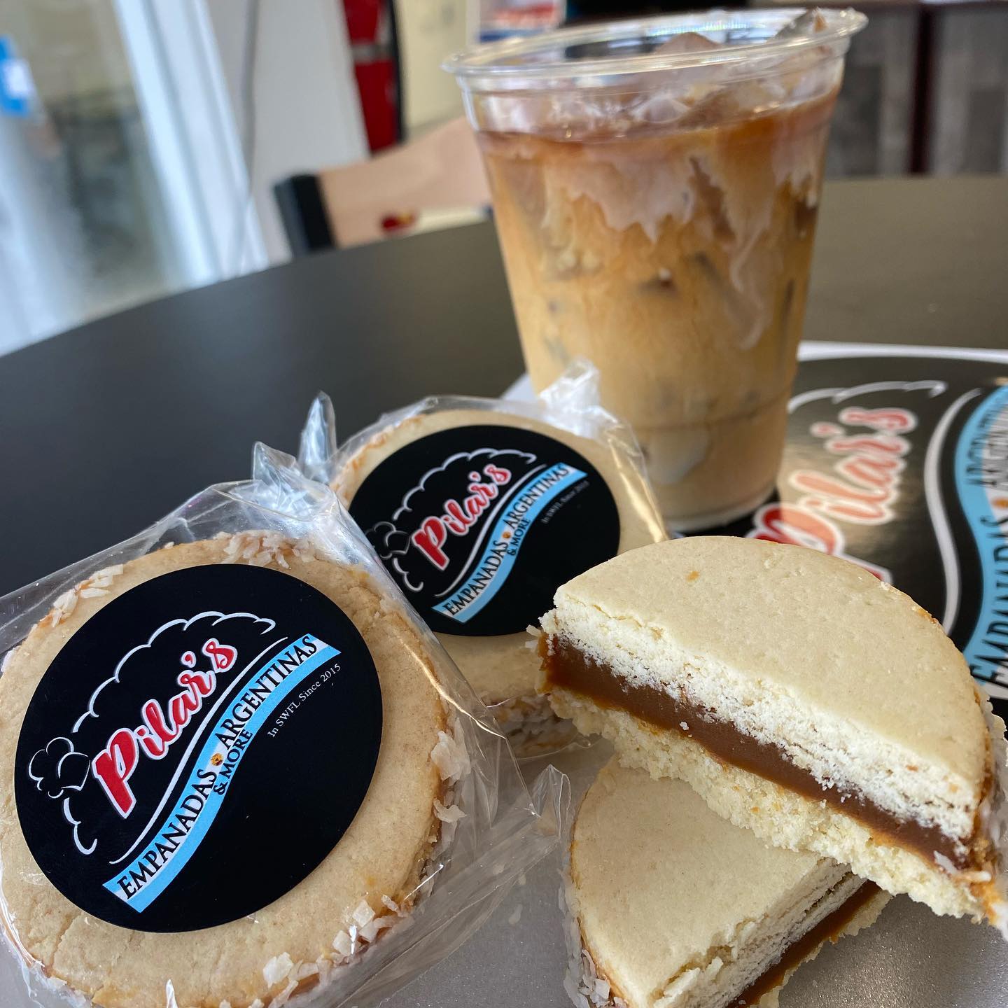 Alfajores cookies with dulce de leche filling, a coffee drink, and a logo,