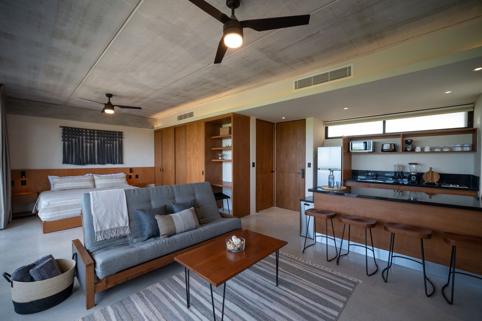 Una sala de estar con sofá, mesa y ventilador de techo.