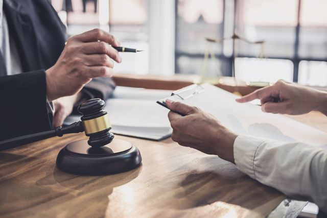A man and a woman are sitting at a table with a judge 's gavel.