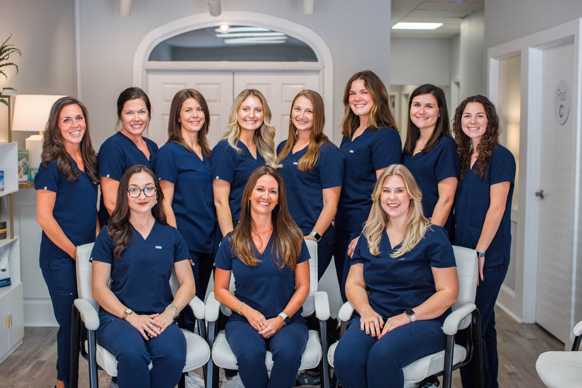 A group of women in scrubs are posing for a picture.