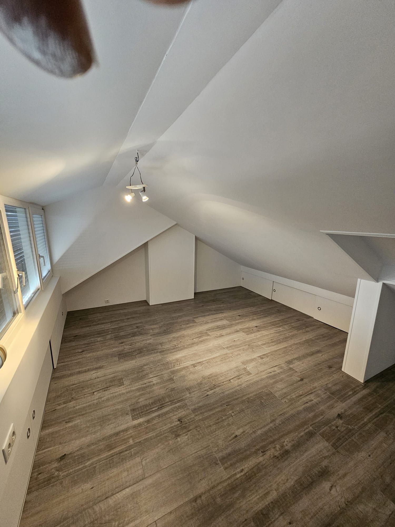 Moderne badkamer met zwarte marmeren douche, dubbele wastafel, spiegel en wasmachine en droger bij het raam.