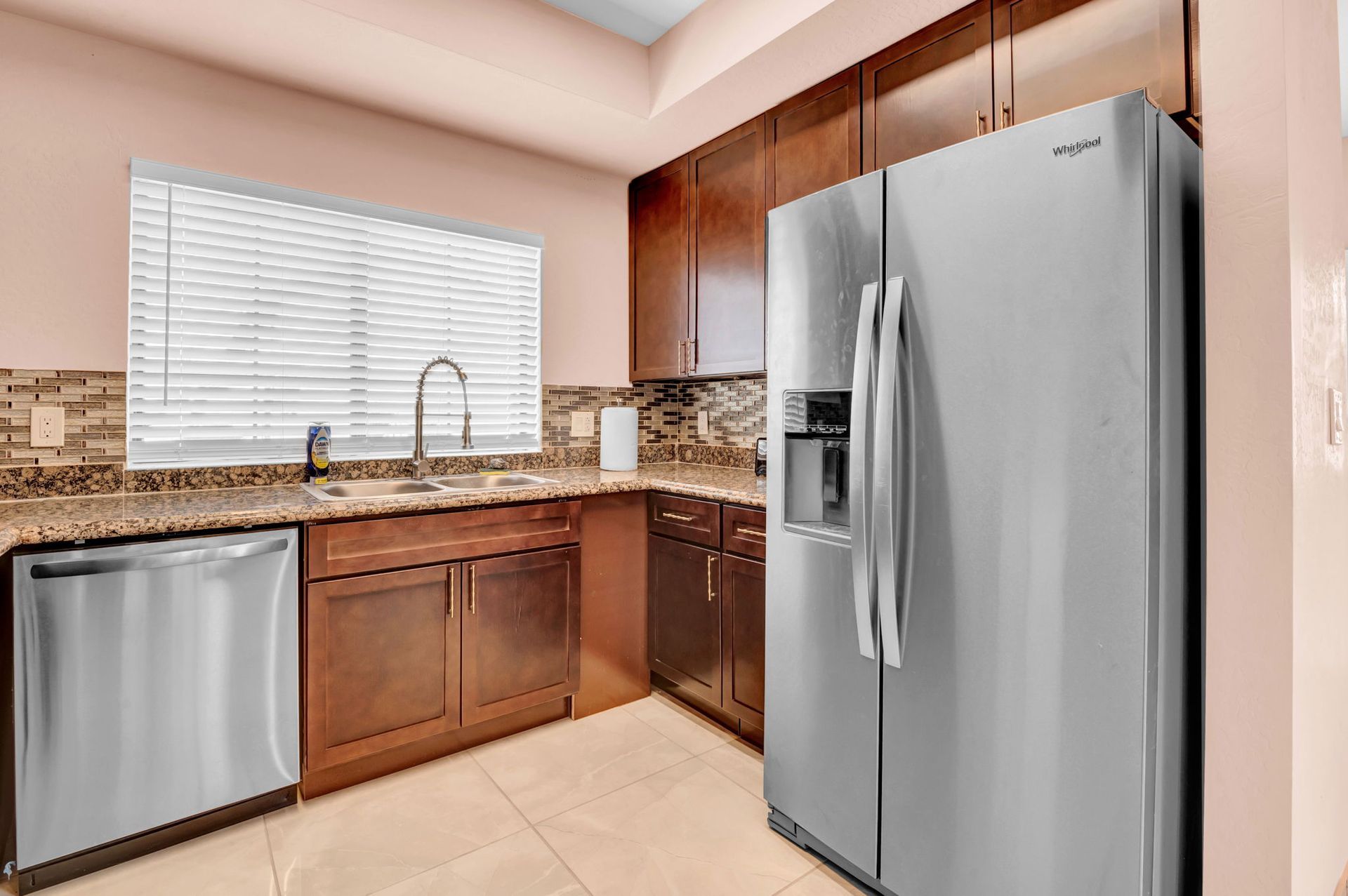 Kitchen with stainless steel appliances, dark wood cabinets, and granite countertops.