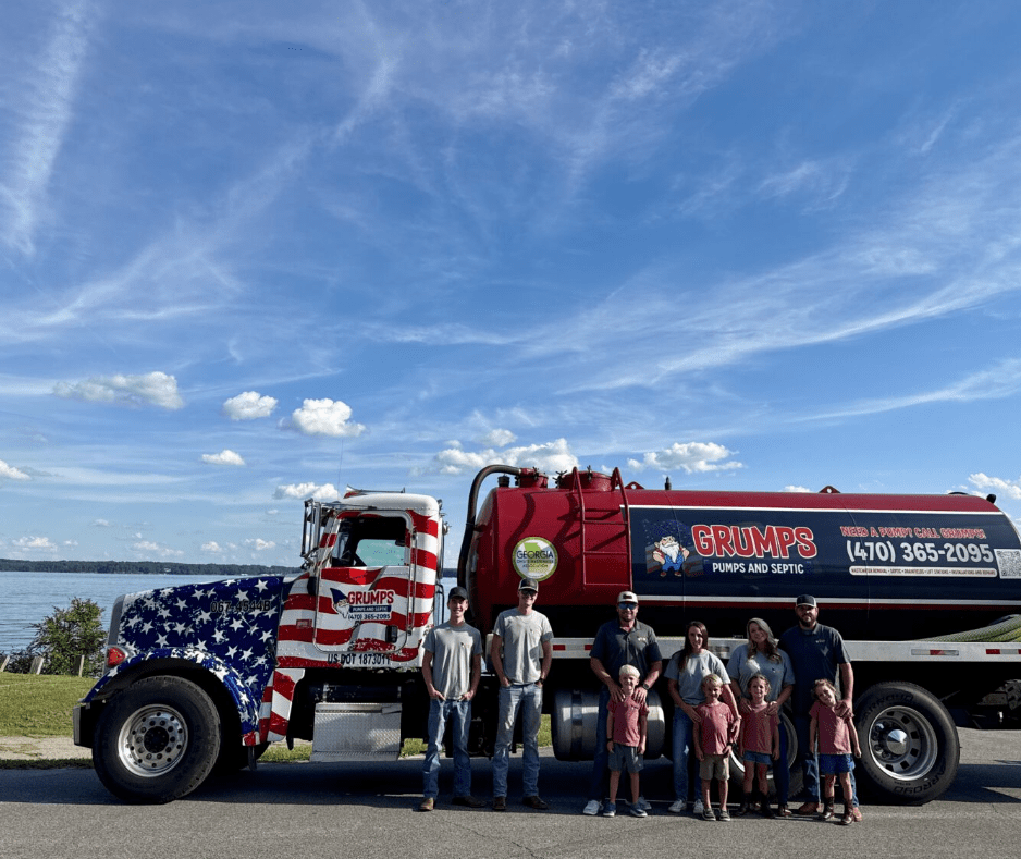 Fire truck with American flag paint and a group posing beside it under a blue sky