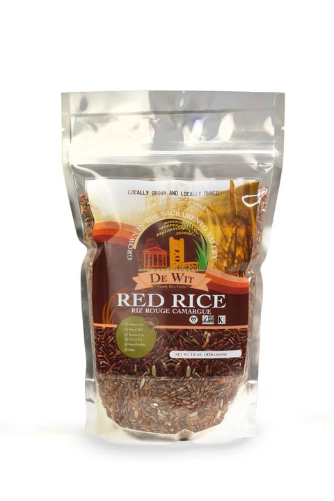 Clear resealable bag of red rice with brown label and white text on a plain background