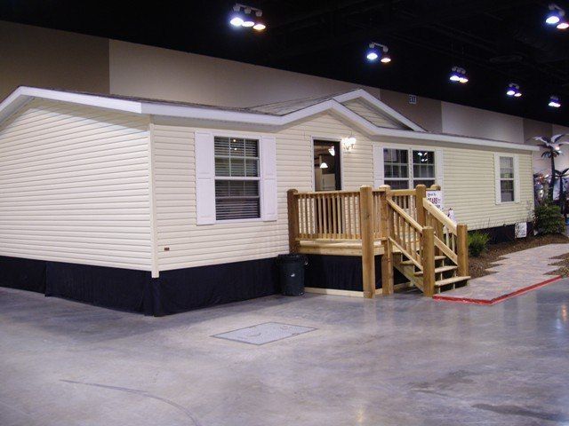 A mobile home with a wooden deck and stairs