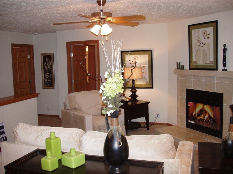 A living room with a fireplace and a ceiling fan