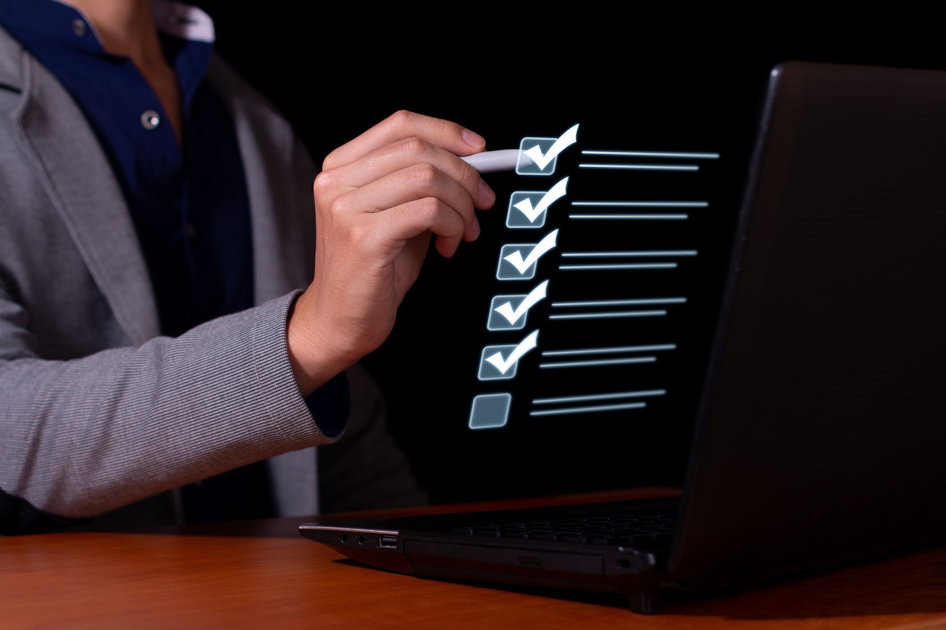 Person checking off items on a digital checklist displayed on a laptop screen.