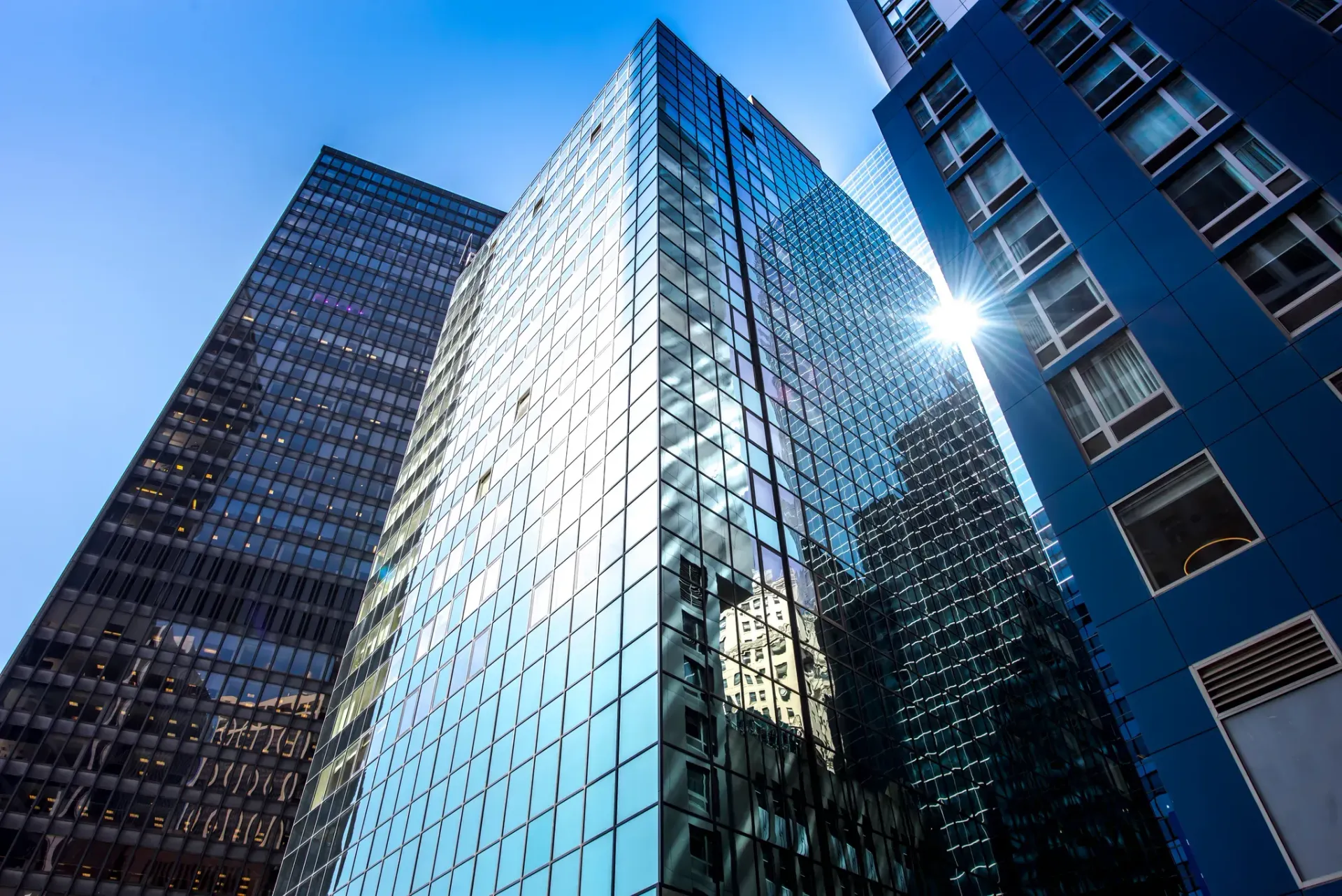 Four people walking through a modern city plaza with tall buildings in the background