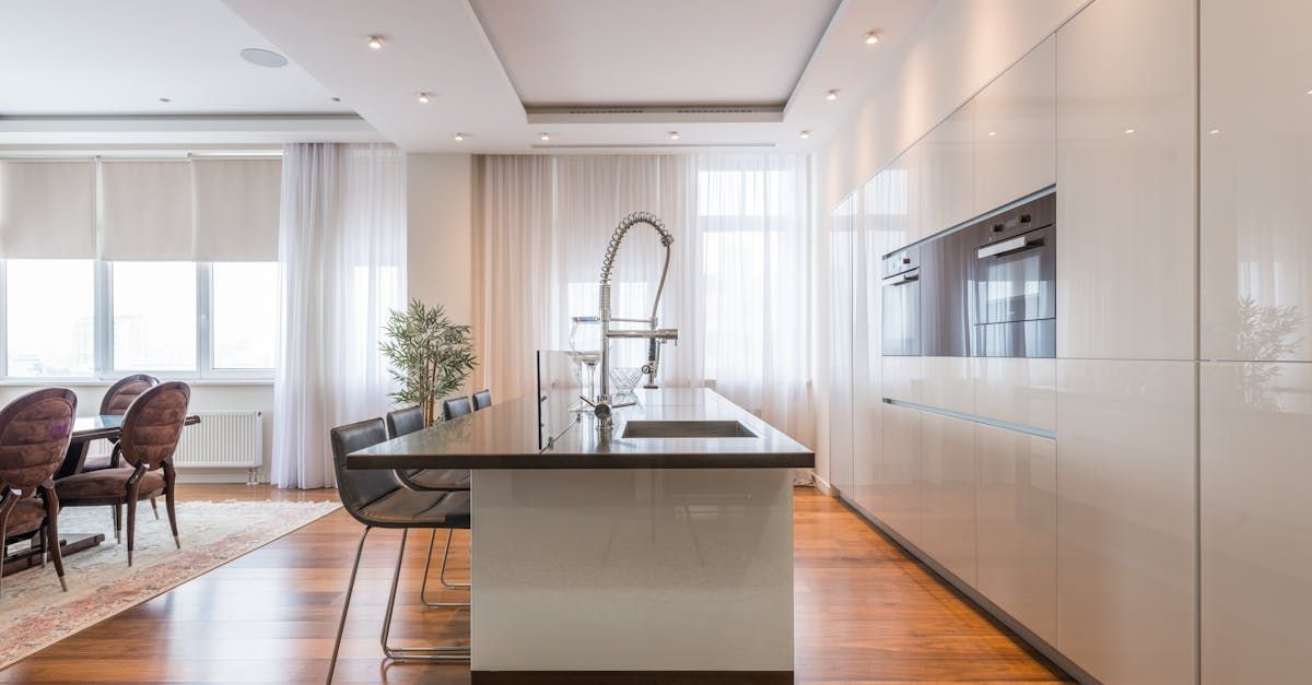 A kitchen with a large island in the middle and a dining room in the background.