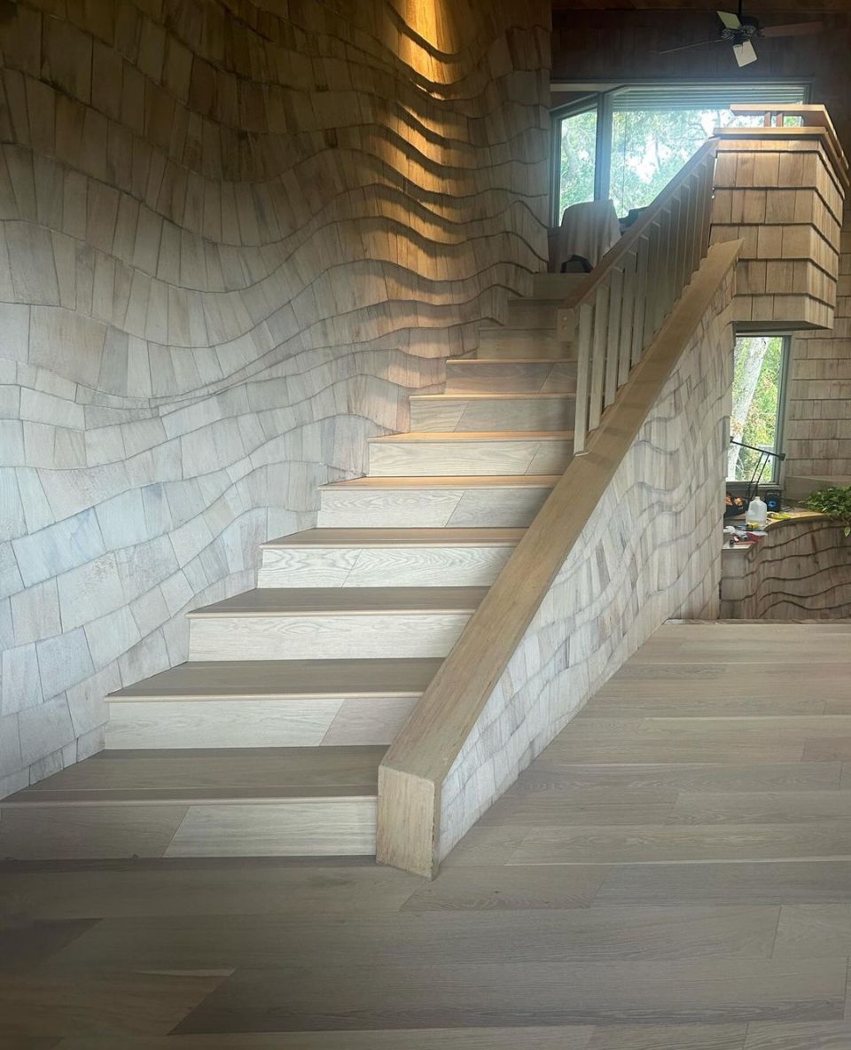 Custom oak staircase with natural wood wall panels and modern hardwood flooring installed by Core Flooring FL