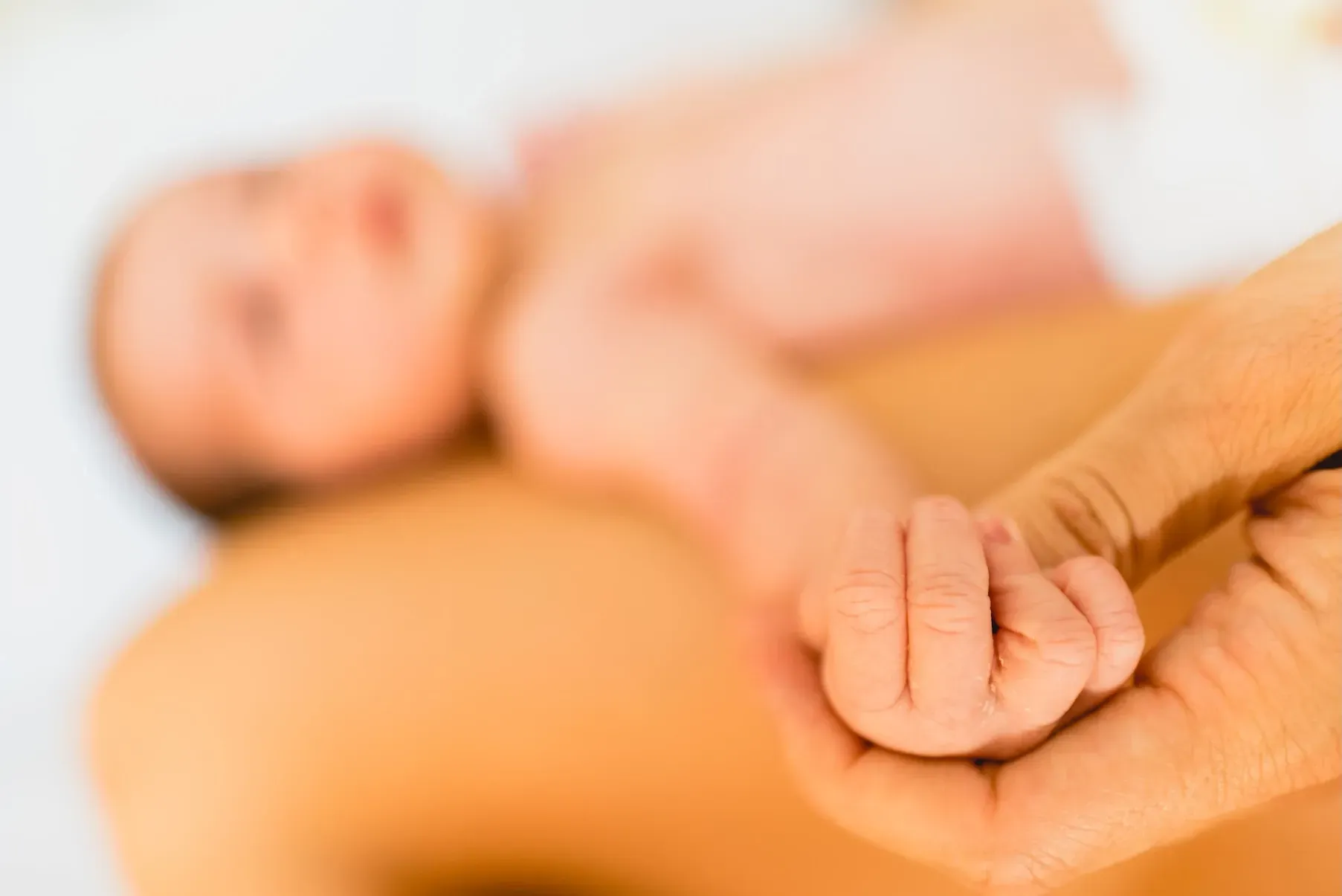 Un bébé joue avec un animal en peluche sur un lit.