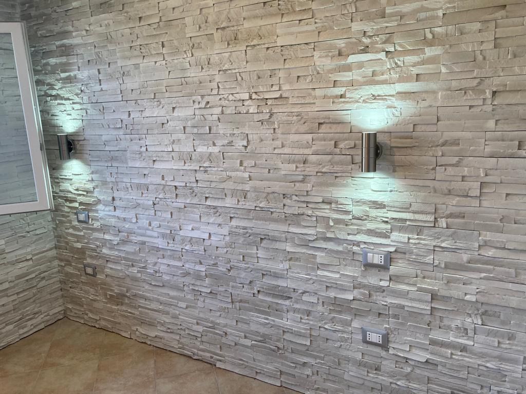 Una stanza con un muro di mattoni e due luci sul muro.
