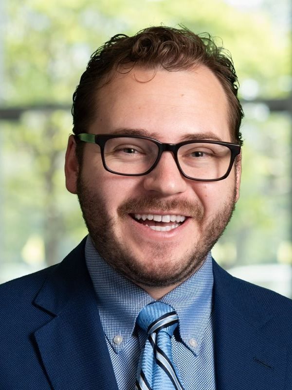 Slocum Pickell Attorney in Little Rock, Arkansas Smiling man in glasses and a blue suit jacket with a striped tie.