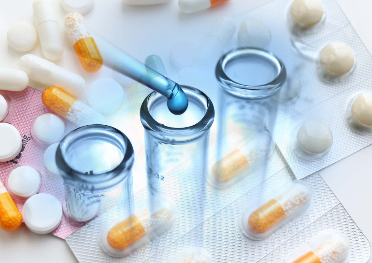 Environnement de laboratoire avec capsules, pilules et flacons ; un compte-gouttes distribue le liquide.