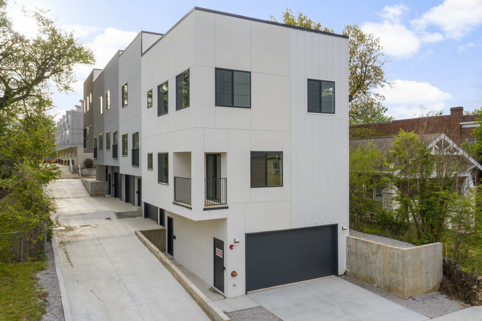 A white building with a black garage and a lot of windows