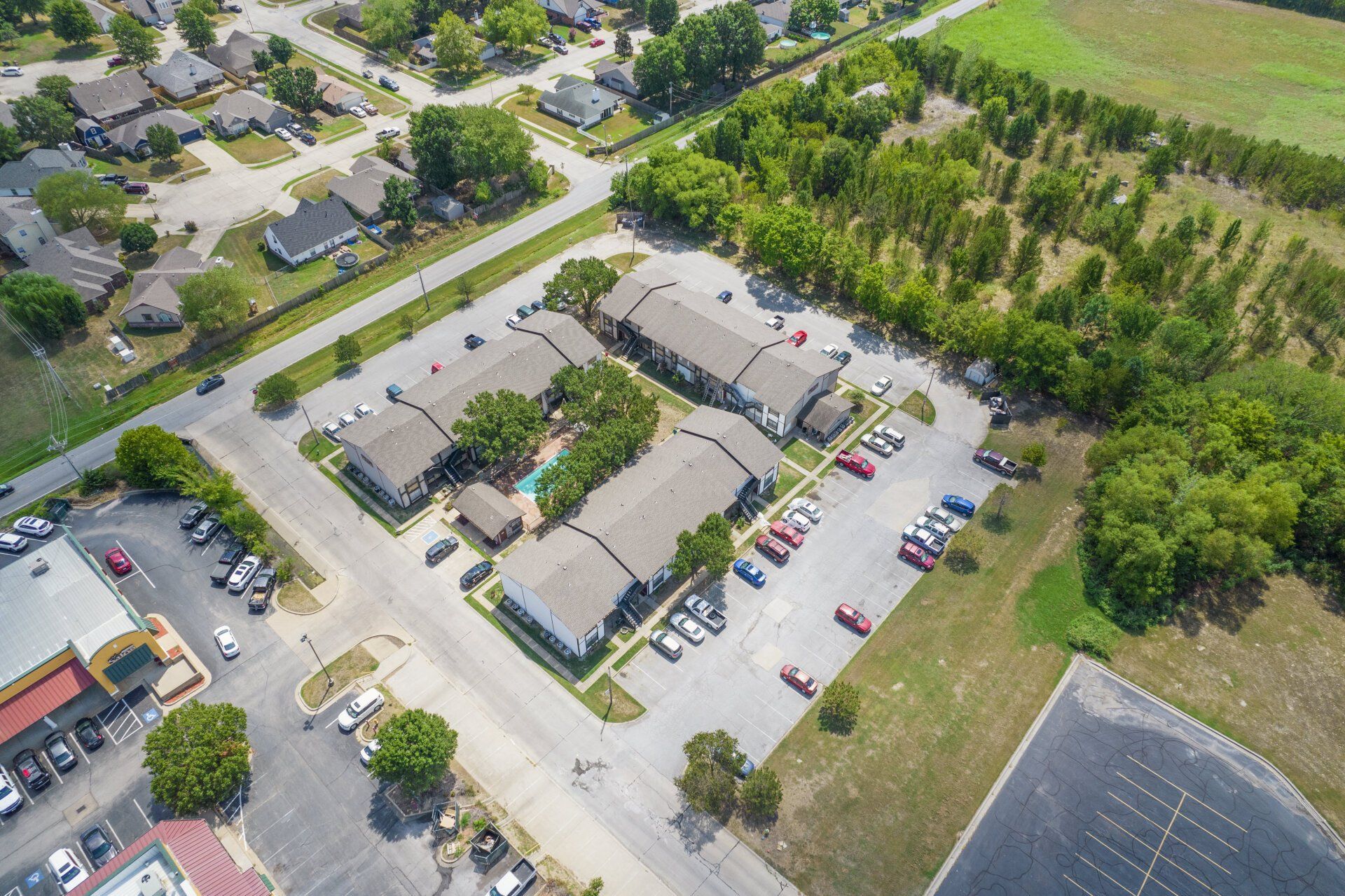 An aerial view of a residential area with lots of cars parked in a parking lot.
