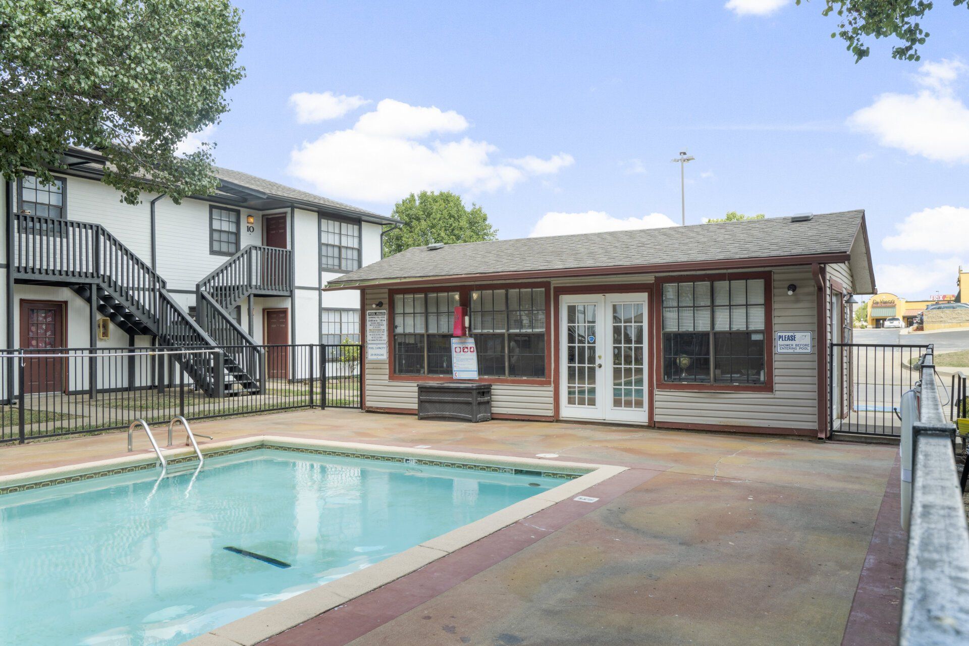 There is a large swimming pool in front of a building.