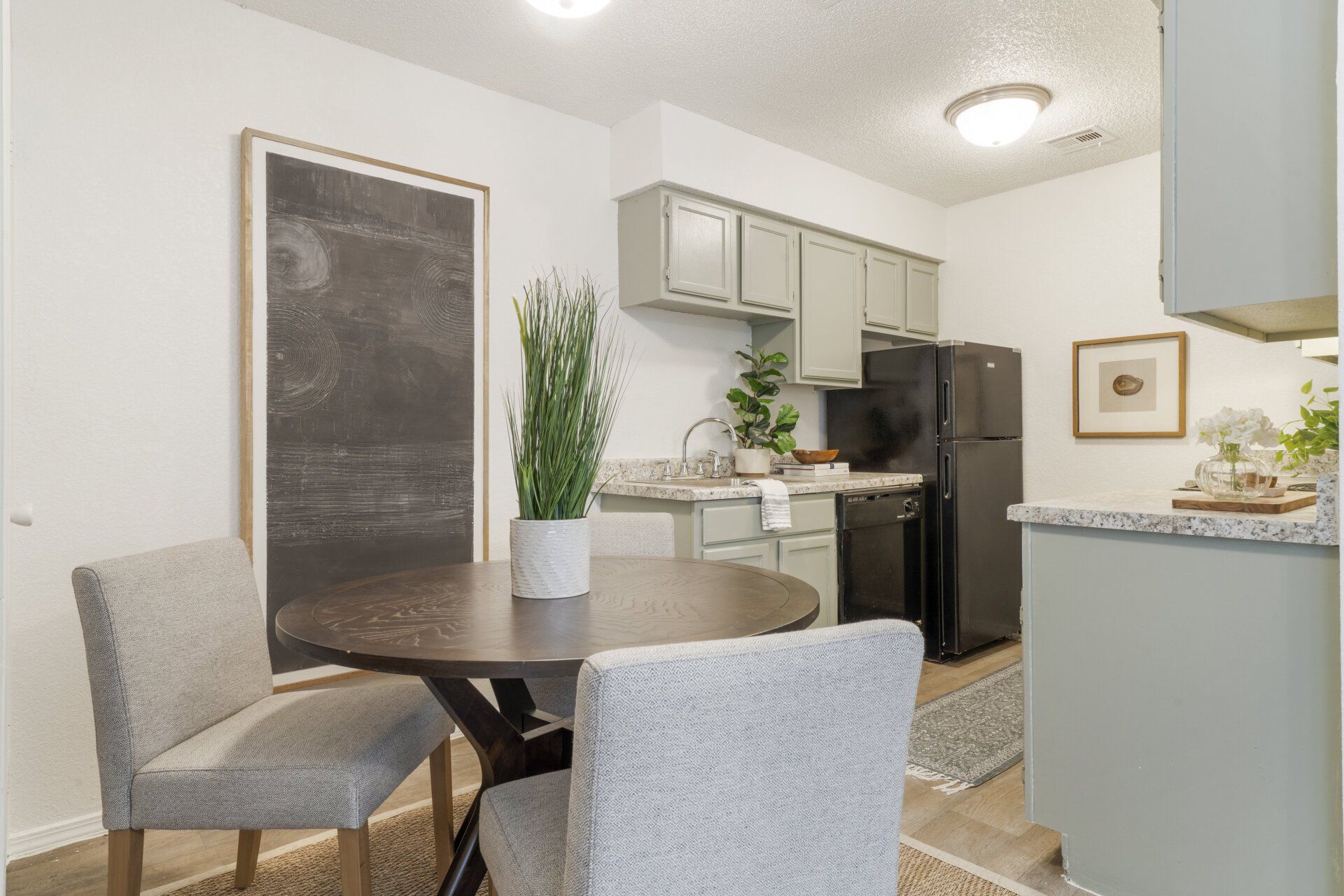 A kitchen with a table and chairs and a refrigerator.