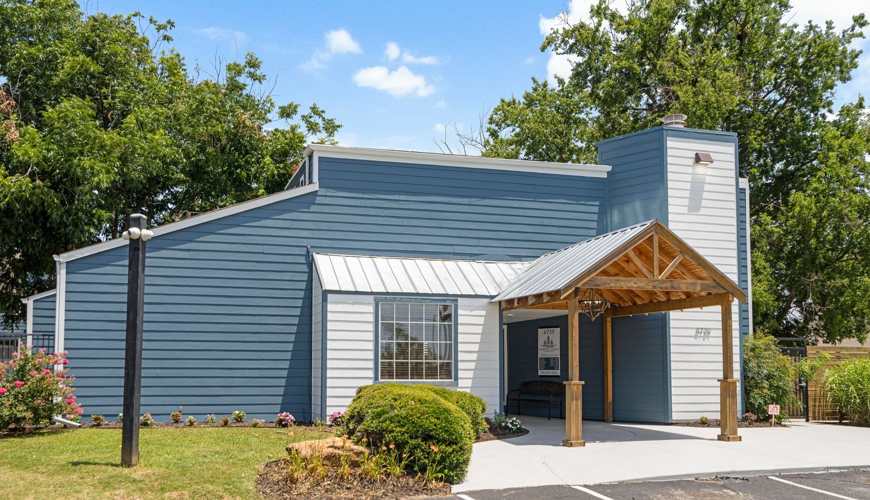 A blue and white house with a wooden porch in front of it.
