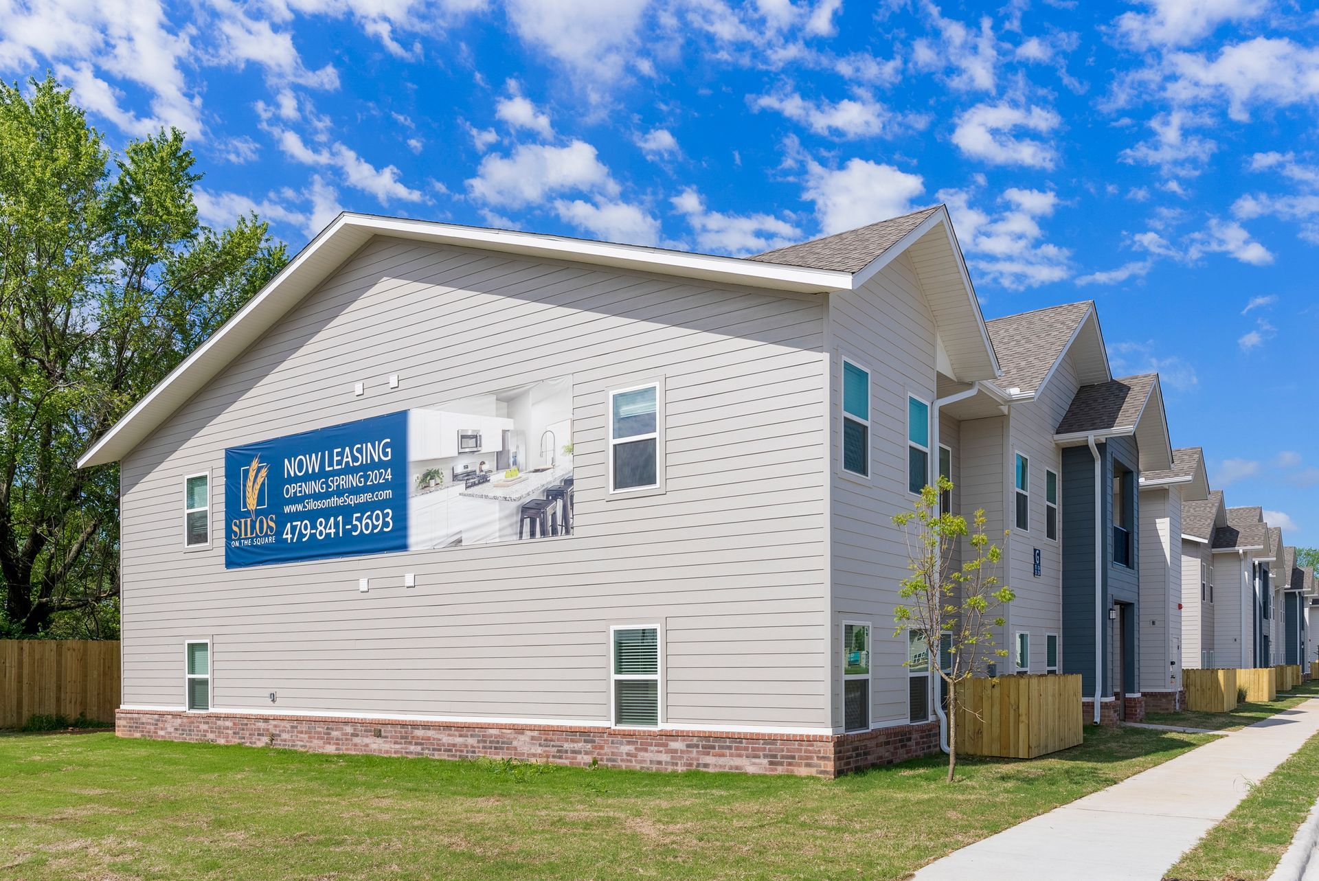 A white apartment building with a blue sign on the side of it.