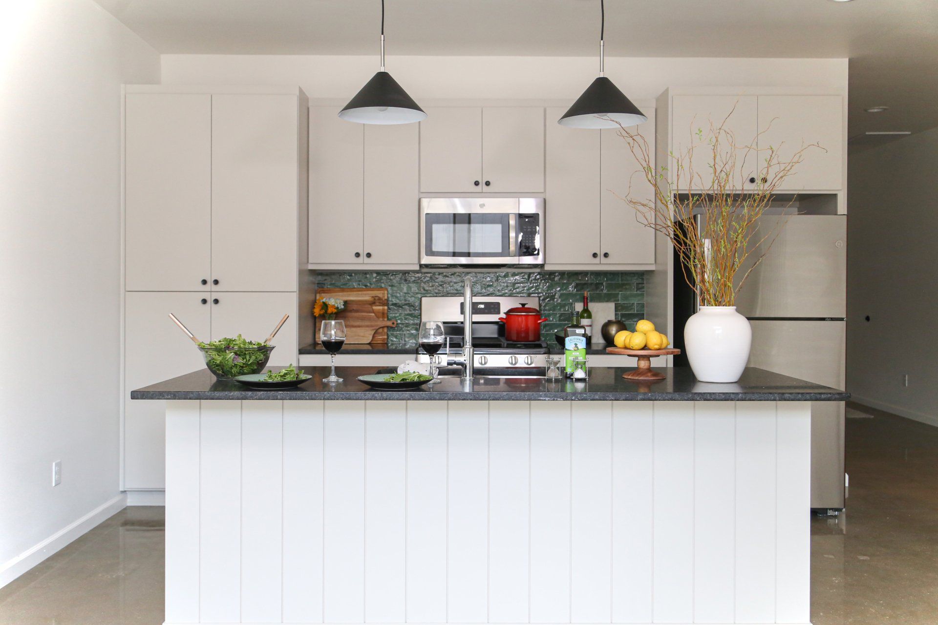 A kitchen with white cabinets and a large island in the middle