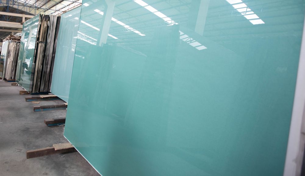 A Large Piece Of Glass Is Sitting On Top Of A Wooden Pallet In A Warehouse — New England Glass & Aluminium In Inverell, NSW