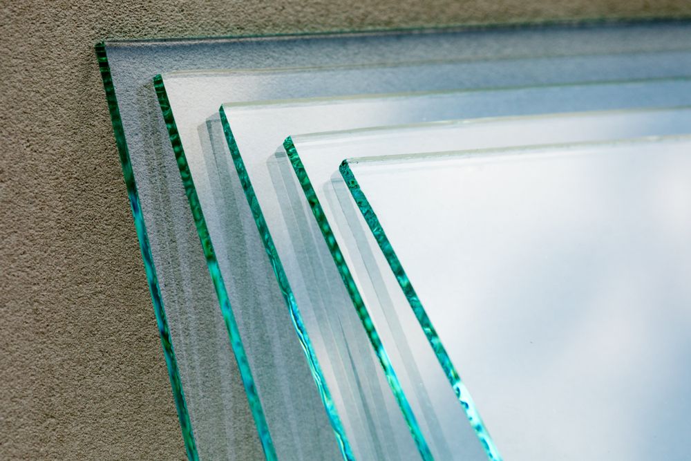 Three Pieces Of Glass Are Stacked On Top Of Each Other On A Table — New England Glass & Aluminium In Armidale, NSW