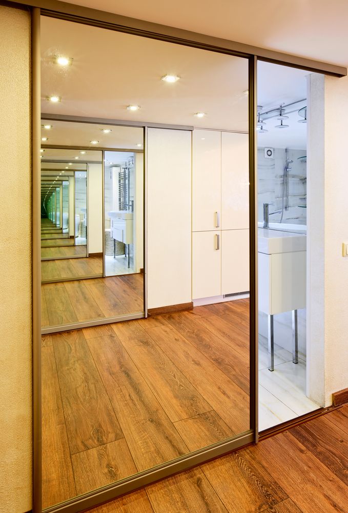A Hallway With A Large Mirror On The Wall Leading To A Bathroom — New England Glass & Aluminium In Armidale, NSW
