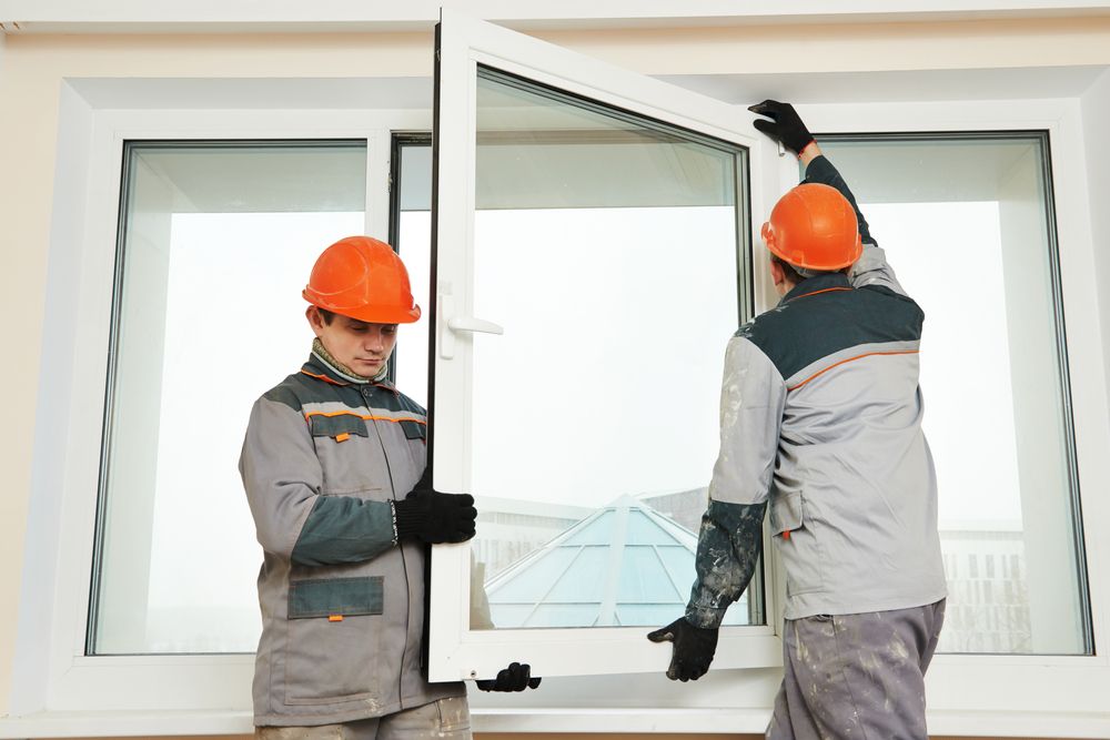 Two Men Are Installing A Window In A House — New England Glass & Aluminium In Guyra, NSW