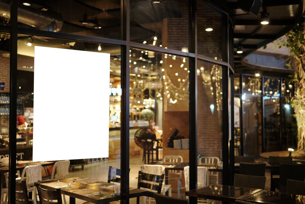A Restaurant With Tables And Chairs And A White Sign In The Window — New England Glass & Aluminium In Armidale, NSW