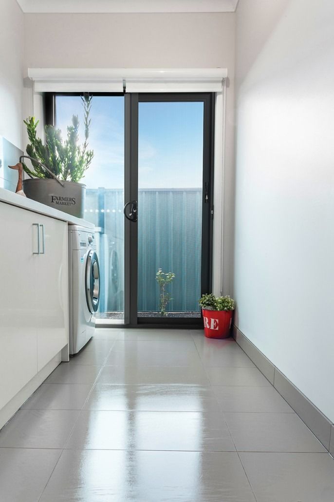 A Laundry Room With A Sliding Glass Door And A Washing Machine — New England Glass & Aluminium In Armidale, NSW